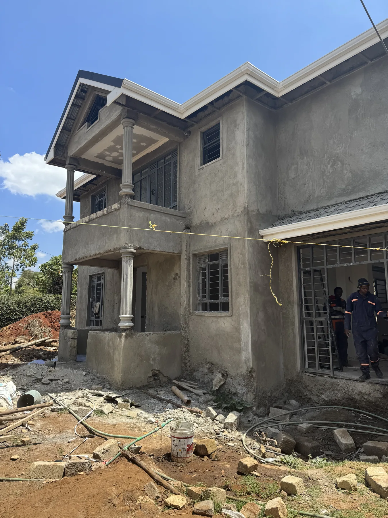 Construction site: the plastered front of a two-storey house with its balcony and window grilles