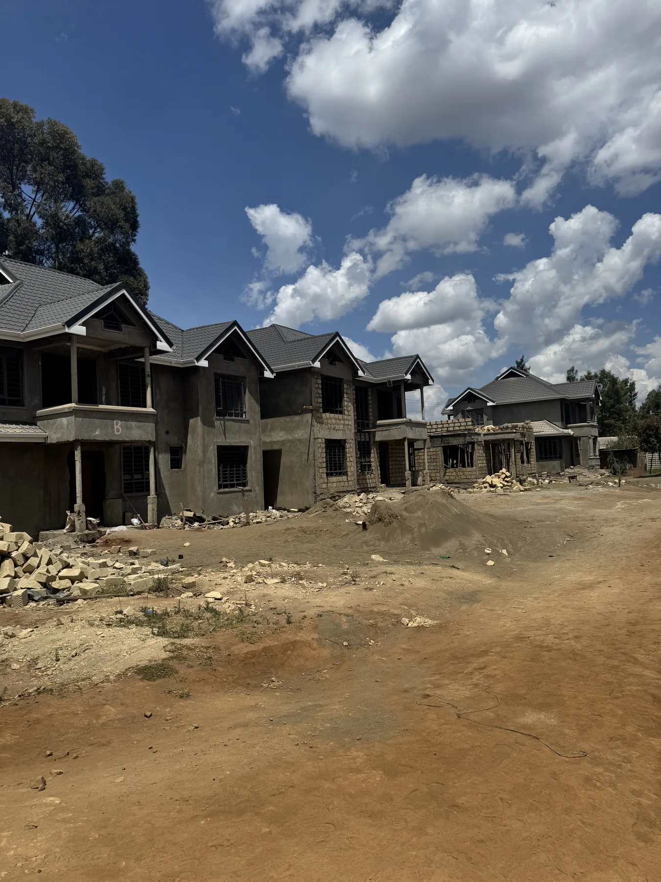 Construction site: a row of roofed two-storey houses along the estate road